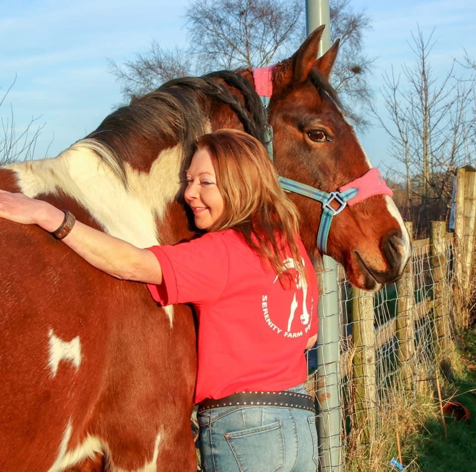 Lucy Wheeler hugging one of the farm horses